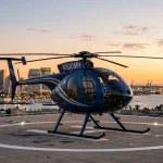 MD 500 light turbine helicopter parked on a scenic modern helipad