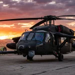 Sikorsky MH-60M special operations military helicopter on desert runway at dramatic sunset