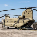 Boeing CH-47 Chinook tandem rotor military helicopter parked on airfield tarmac