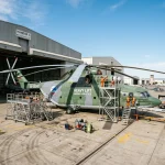 Mil Mi-26 giant heavy lift helicopter parked outside hangar showing massive scale